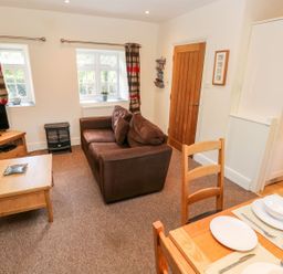 A living room with a sofa and television at Swallows Cottage in Clarbeston Road