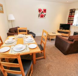 A dining area with a table set for meals at Swallows Cottage in Clarbeston Road