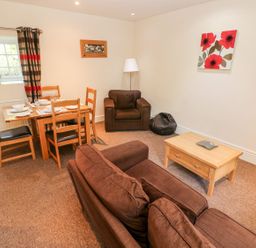 A living room with a table and chairs at Swallows Cottage in Clarbeston Road