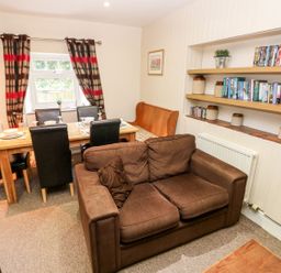 A dining room with a table and chairs at Lake Cottage in Clarbeston Road