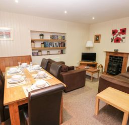 A dining room with a table and chairs at Lake Cottage in Clarbeston Road