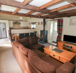 A living room with a sofa and dining area at Granary Cottage, Clarbeston Road