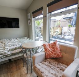A bedroom with a bed and a table at Cabin At The Brig Annan