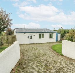A cottage with a driveway in front at Harbour Lights in Holyhead