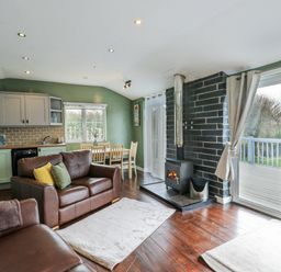 A living room with a sofa and dining area at Harbour Lights in Holyhead