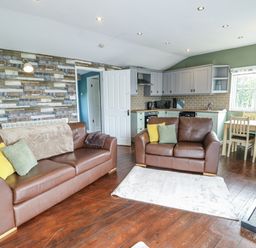A living room with sofas and dining table at Harbour Lights in Holyhead