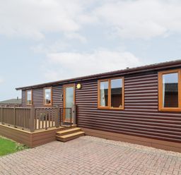 A wooden cabin with a deck and windows at Ocean Terrace 28 Ilfracombe