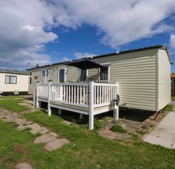 A static caravan with a deck and patio at Hideaway Lodge in Abergele