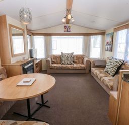 A living room with a coffee table and sofas at Hideaway Lodge in Abergele