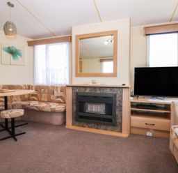 A living room with a table and seating area at Hideaway Lodge Abergele