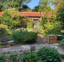A garden with plants and seating at The Old Post Box 
