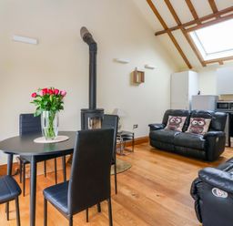 A living room with a dining table and chairs at The Owl Barn Cottage 