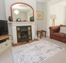 A living room with a television, fireplace, and sofa at Pedn Brose Near Mousehole