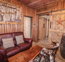 A living room with a sofa, wooden table and decorative wall art at The Rusty Barn in Limavady