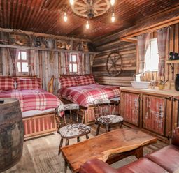 A bedroom with two beds and a wooden table at Rusty Barn in Limavady