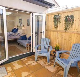 An outdoor seating area with blue chairs and a table at Sea Folly