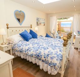 A bedroom with a double bed and a door leading outside at Sea Folly