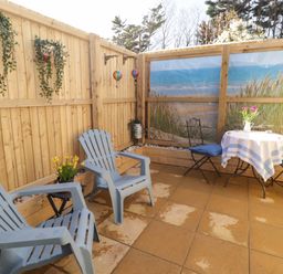 An outdoor patio with chairs and a table at Sea Folly 