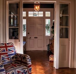 A hallway with an armchair and a door at St Anne's Manor in Torquay