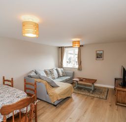 A living room with a sofa and dining table at Starlight Cottage in 