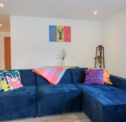A living room with a blue sofa and colorful pillows at Barn 5