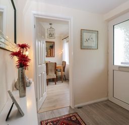 A hallway with a mirror and flowers at Apple Byrd in Kendal