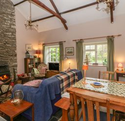 A living room with couch and fireplace at Tyn Y Fron Brynherbert near Llanrhystud