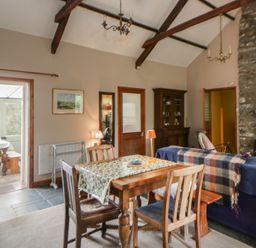 A dining room with a table and chairs at Tyn Y Fron in Brynherbert near Llanrhystud