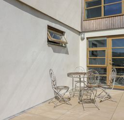 An outdoor seating area with a table and chairs at Teach Tra East in Perranporth