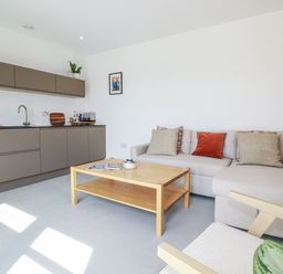 A living room with a sofa and coffee table at Teach Tra East Perranporth