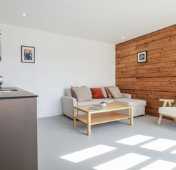 A living room with a sofa and a coffee table at Teach Tra East in Perranporth