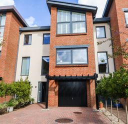 A townhouse with a garage and plants at Harbour Heights in Weymouth