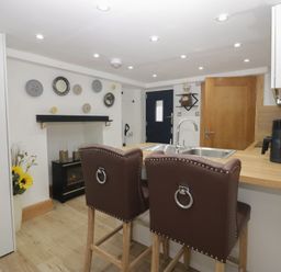 A kitchen with bar stools and a fireplace at Park View Studio in Ambleside