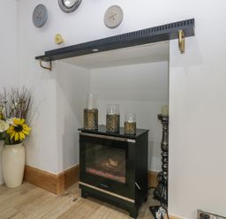 A snug with an electric fireplace and flowers at Park View Studio in Ambleside