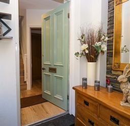 A hallway with a door and a mirror at Park View in Ambleside