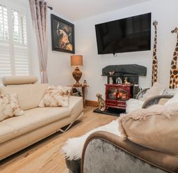 A living room with a fireplace and a sofa at Park View in Ambleside
