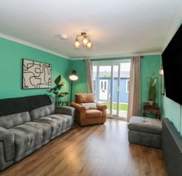 A living room with a sofa and television at 61 Lloyd Street West Llandudno