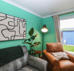 A living room with a sofa and an armchair at 61 Lloyd Street West in Llandudno