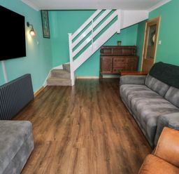 A living room with a sofa and television at 61 Lloyd Street West Llandudno