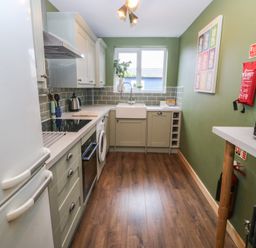 A kitchen with a sink and refrigerator at 61 Lloyd Street West Llandudno