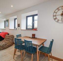 A living room with a dining table and a sofa at Barn 2 