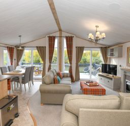 A living room with a sofa and dining table at Lakewood Retreat in Woodhall Spa