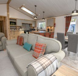 A living room with a sofa and dining area at Lakewood Retreat in Woodhall Spa