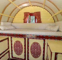 A sleeping area with a bed and cabinets at The Bowtop Gypsy Caravan in Eye