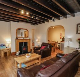 A living room with a fireplace and seating area at 2 High Stakesby Cottages in Whitby