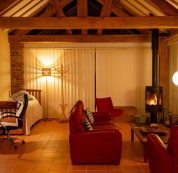 A living room with red sofa and a television at Nature's Lodge in Cookley