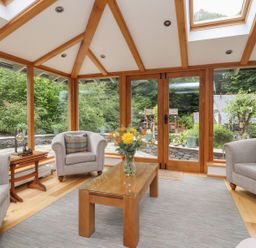 A conservatory with seating and a table at Bobbin Mill Cottage in Ulverston