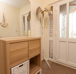 A hallway with a mirror and a hat rack at Gelli - Morfa Nefyn