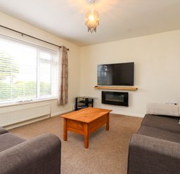 A living room with sofas and a television at Gelli - Morfa Nefyn in Morfa Nefyn