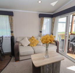 A living room with a sofa and a table at Stag Lodge, Caravan 70 Great Yarmouth